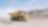 yellow dumper truck driving through gravel