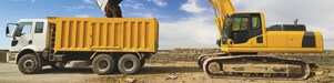 yellow excavator loading mud into a truck