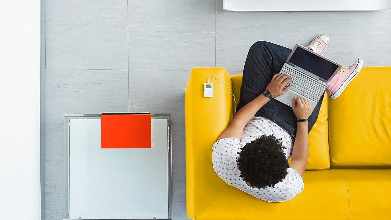 A man sitting on a sofa with his laptop