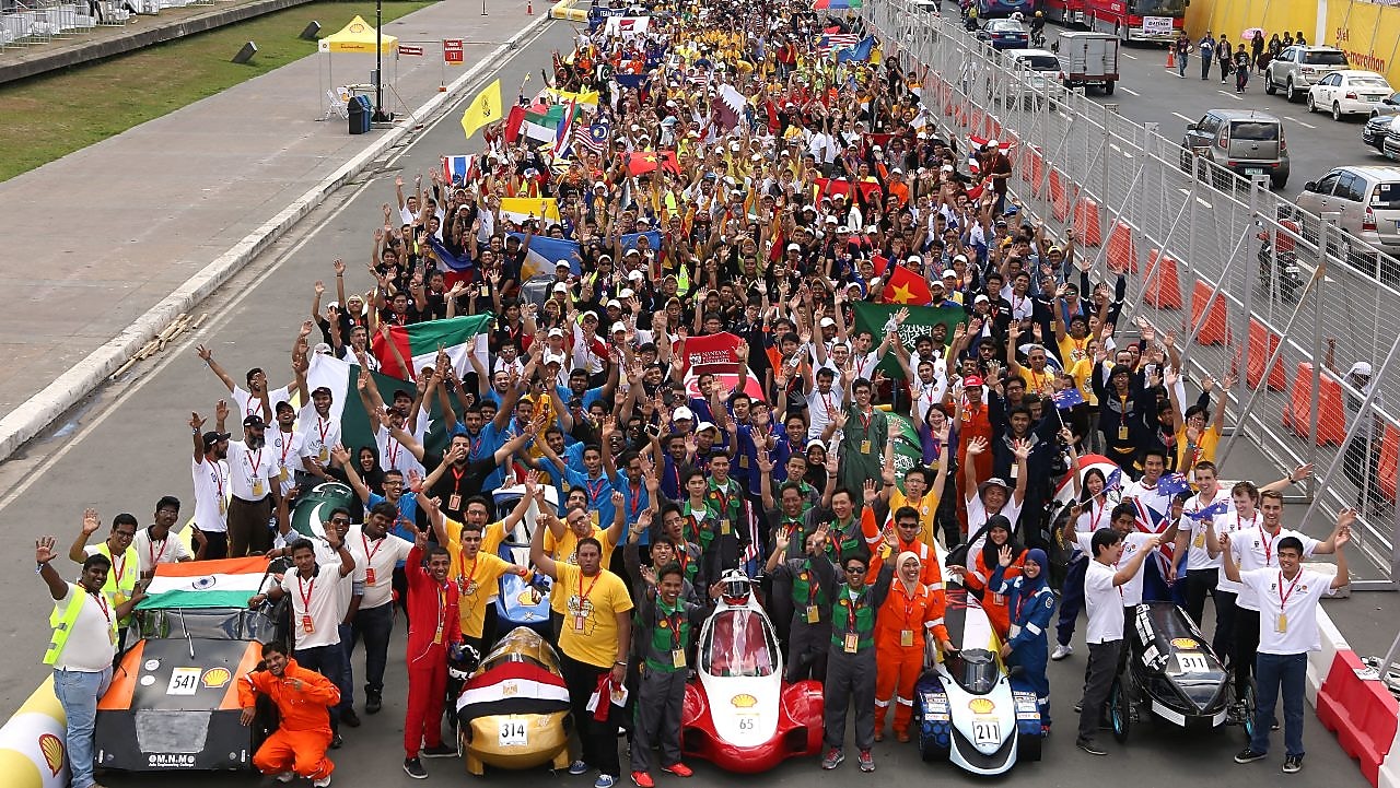 Participants pose with their vehicles during day one of the Shell Eco-marathon in Manila