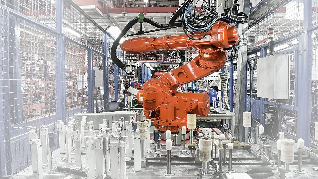 a red robotic arm in a factory