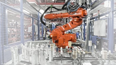 a red robotic arm in a factory