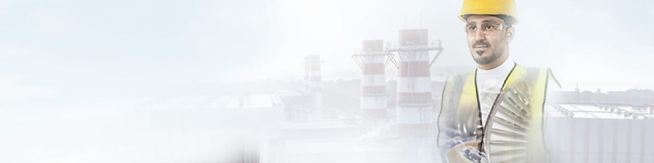 worker in a yellow hard hat transposed onto a background of a power plant