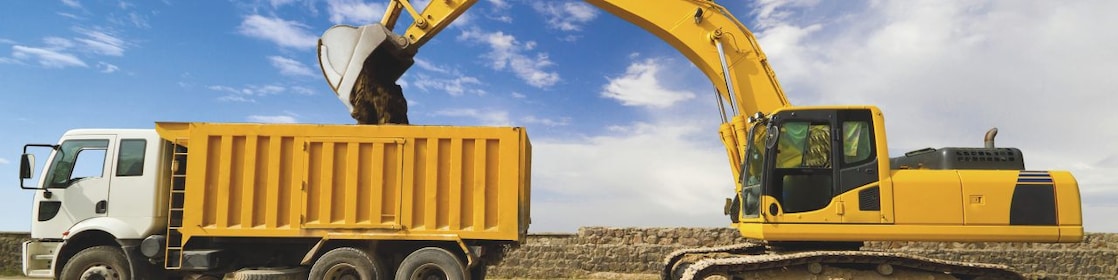 yellow excavator loading mud into a truck