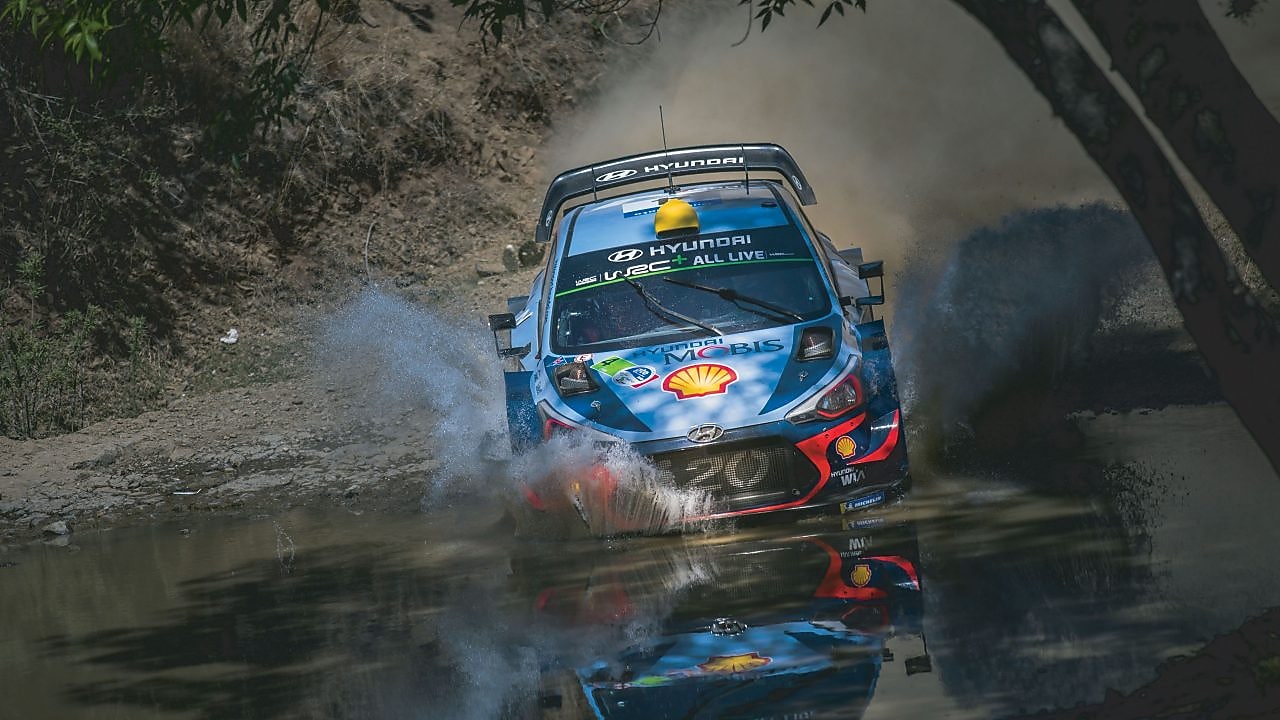 An Hyundai Shell World Rally Team car racing through a forest