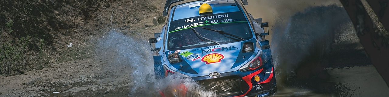 An Hyundai Shell World Rally Team car racing through a forest